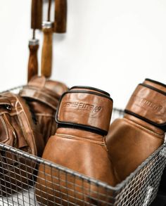 several pairs of brown leather gloves in a basket