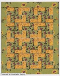 a yellow and green quilt with red flowers on the center, in front of a checkerboard pattern