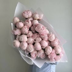 a person holding a bouquet of pink flowers