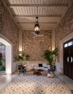 a living room filled with furniture and a stone wall