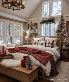 a bedroom decorated for christmas with red and white plaid bedding, pillows, blankets and candles