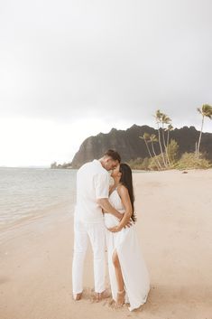 a man and woman kissing on the beach