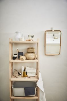 a shelf with towels, soaps and other items on it in front of a mirror