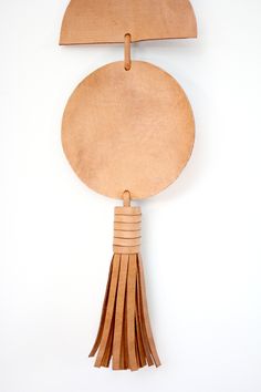 a piece of leather with tassels hanging from it's side on a white wall