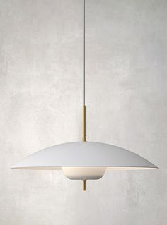 a white light hanging from a ceiling in a room with concrete walls and flooring