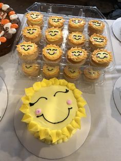 there are many cupcakes on the table with faces drawn on them and one has a smiley face