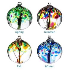 four different colored glass ornaments with trees in the center and words spring, summer, fall, and winter