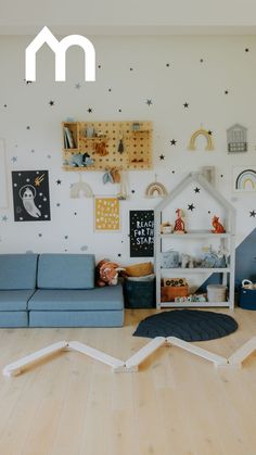 a living room with blue couches and stars on the wall above it is a playroom for children