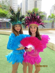 two girls dressed in colorful costumes posing for the camera