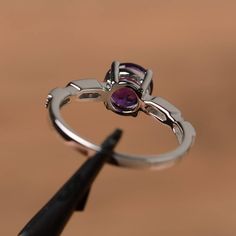 It is a natural amethyst ring. The main stone is 7mm*7mm round cut, weight about 1.25 carats. The basic metal is sterling silver and plated with rhodium. To change the metal to a solid gold (white/rose) or platinum is also available, please ask for a quotation if you want. You can also go to my shop Home for more elegant rings: https://www.etsy.com/shop/godjewelry?ref=hdr_shop_menu Amethyst is February birthstone. Customization is always welcome and please feel free to contact with me if you hav Engagement Ring Silver, February Birthstone Ring, Round Cut Engagement Ring, Elegant Rings, Rings Gemstone, Purple Amethyst Ring, Round Cut Engagement Rings, February Birthstone, Elegant Ring