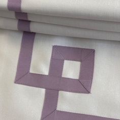 purple and white fabric with an interlocked design on the bottom half of it