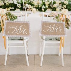 two chairs with mr and mrs signs sitting on top of each other in front of a table