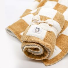 a brown and white checkered towel folded on top of each other with a bow