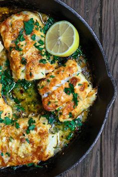 a skillet filled with chicken covered in sauce and garnished with parsley