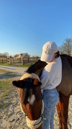 a woman is petting a horse on the nose