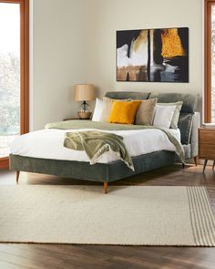 a bedroom with a large bed and wooden floors