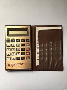 a calculator sitting next to a wallet