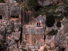 two people standing on the edge of a cliff