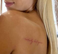 the back of a woman's shoulder with writing on it