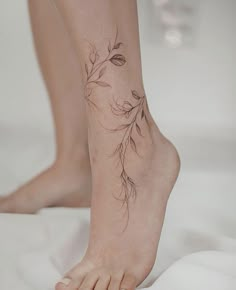 a woman's bare foot with a flower tattoo on her left side and the bottom part of her leg