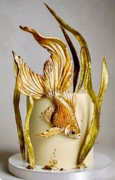 a cake decorated with gold fish and seaweed