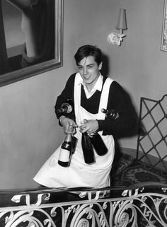 a woman in an apron holding two bottles of wine