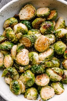 a white bowl filled with brussel sprouts on top of a table