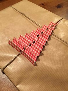 a piece of brown paper with a red and white checkered christmas tree on it