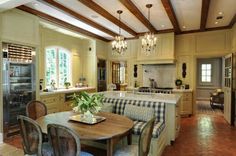 a kitchen and dining room are shown in this image, with wood beams on the ceiling