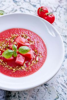 a white bowl filled with watermelon and garnish