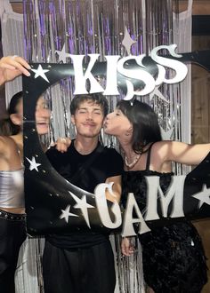 a man and woman kissing in front of a photo booth