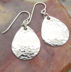 "These lightweight small hammered teardrop earrings are made from solid sterling silver. We have four sizes of tear drop earrings, and these are the small, 1-1/4 inch long size. I have textured them with a hammer, cupped them to give them a bit of a dome shape, and tumble polished them for shine and strength. These earrings are hung with several extra links. The links make the teardrops move gracefully and fit more comfortably. The widest part of the teardrop is about a 3/4\" (17 mm) and the len Tear Drop Earrings, Fun Earrings, Tear Drop, Teardrop Earrings, Beautiful Earrings, 4 Inch, Dangle Drop Earrings, Drop Earrings, Sterling Silver