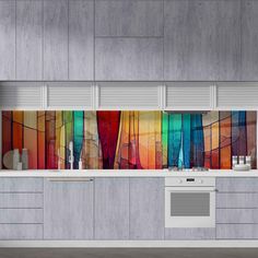 a kitchen with white cabinets and colorful art on the backsplash wall behind it