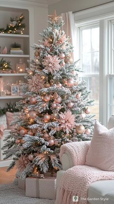 a decorated christmas tree in a living room with pink and silver ornaments on the branches