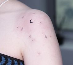 a woman's back with stars and a crescent tattoo on her left shoulder,