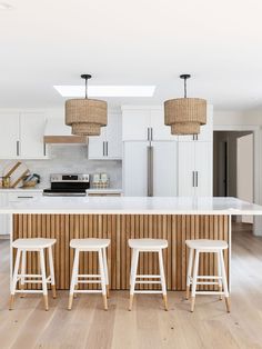 three stools sit at the center of a kitchen island