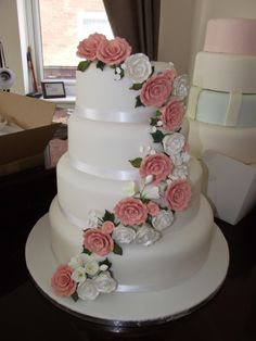 a wedding cake with pink and white flowers on it