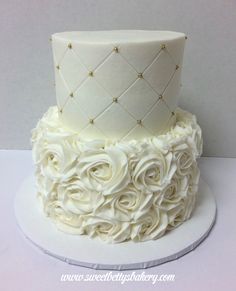 a wedding cake with white frosting and roses