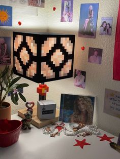 a desk with pictures, photos and a plant on it in front of a lamp