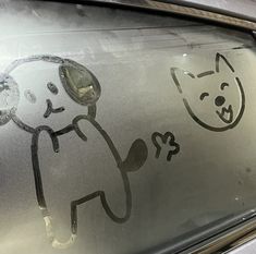 a sticker on the windshield of a car with a cat and dog drawn on it