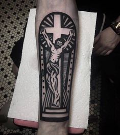 a person with a cross tattoo on their arm