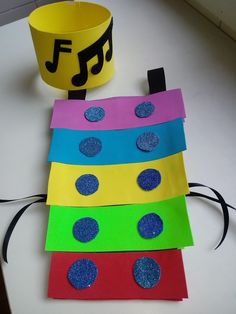 four pieces of paper with circles and music notes on them next to a yellow cup