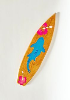 a wooden surfboard with blue and pink designs on it's side, against a white background