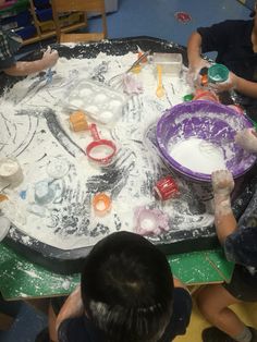 some kids are playing with play dough on a table