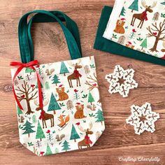 two bags with christmas decorations on them sitting next to some paper snowflakes