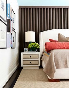 a bedroom with a bed, nightstand and pictures on the wall