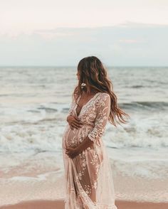 a pregnant woman standing on the beach