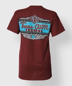 This maroon shirt has a patterned back with the text "Texas A&M Aggies". The front has a faux pocket with a black and white pattern and a blue block ATM. Maroon Shirts, Sports Tee, Black And White Pattern, Blue Block