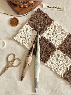 crocheted squares and scissors are on the table