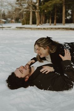 a man and woman laying in the snow